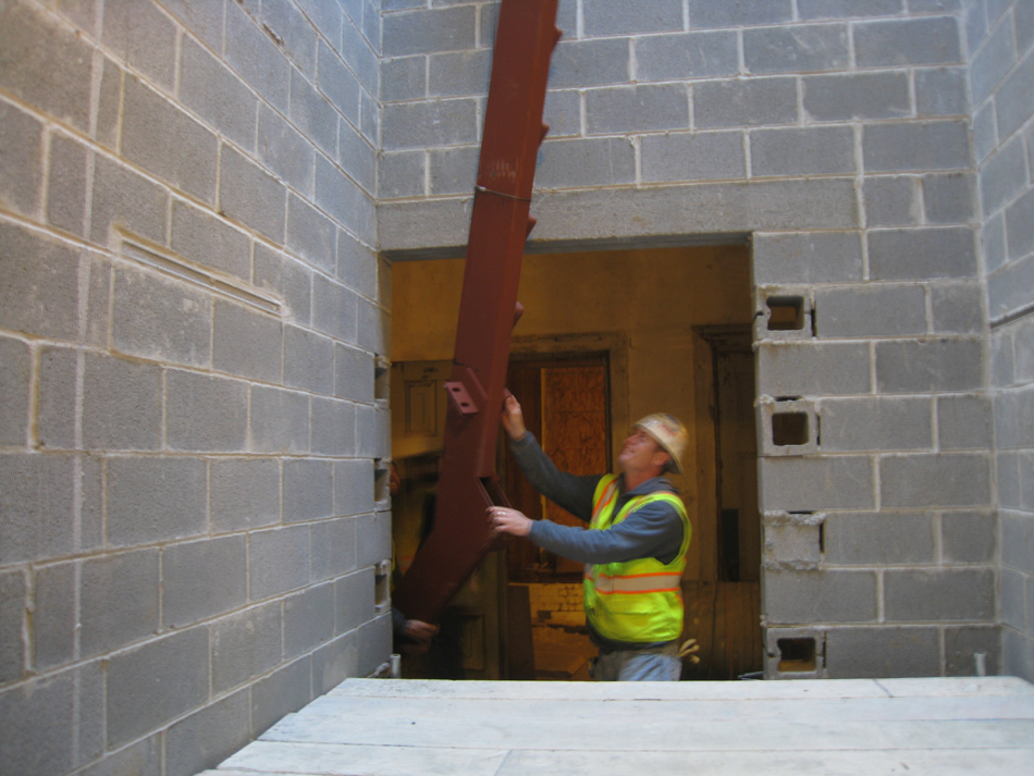 Miscellaneous--Stair elements being lifted into building through the elevator shaft on the second floor