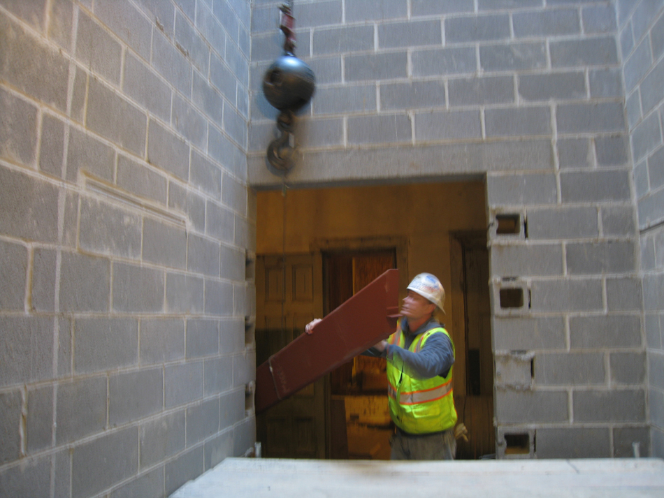 Miscellaneous--Stair elements being lifted into building through the elevator shaft on the second floor