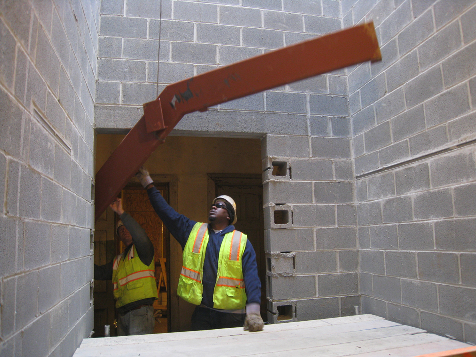 Miscellaneous--Stair elements being lifted into building through the elevator shaft on the second floor