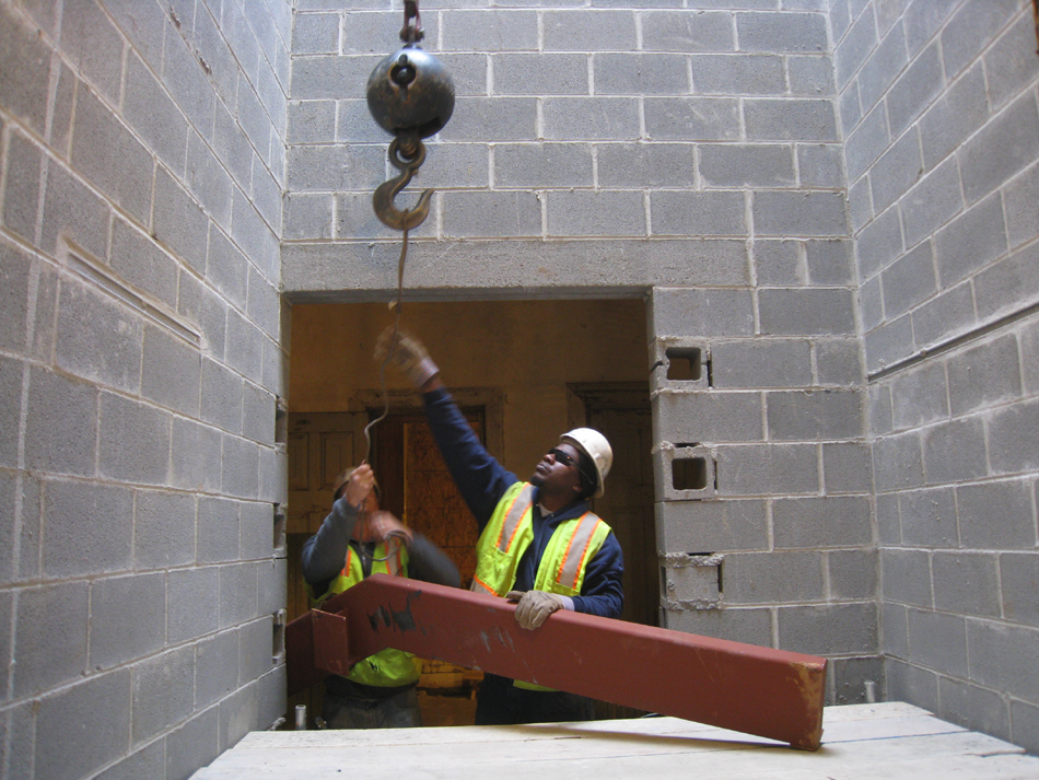 Miscellaneous--Stair elements being lifted into building through the elevator shaft on the second floor