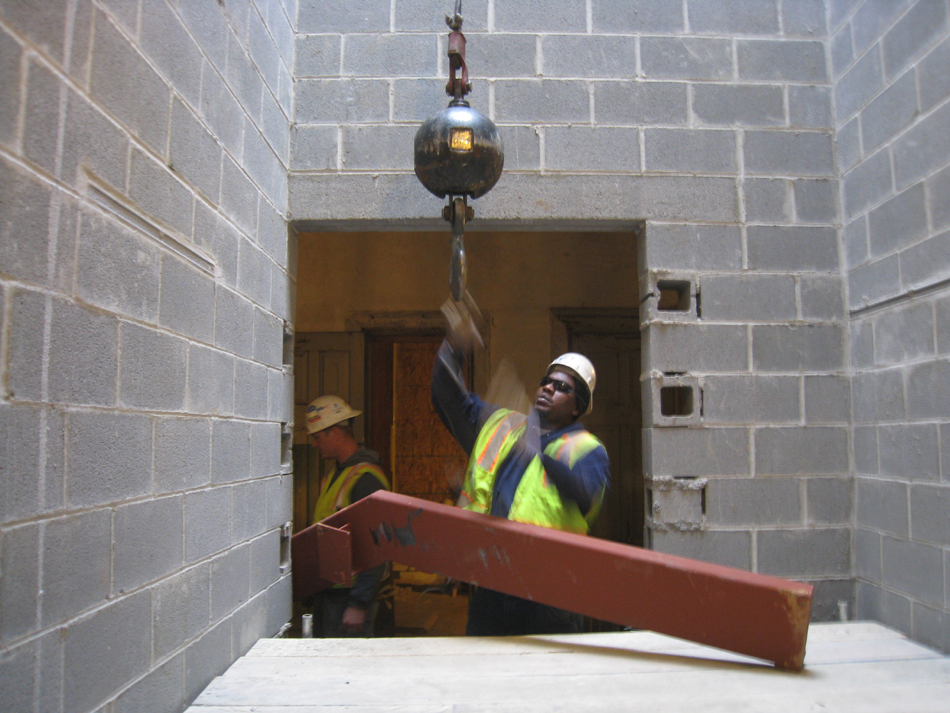 Miscellaneous--Stair elements being lifted into building through the elevator shaft on the second floor