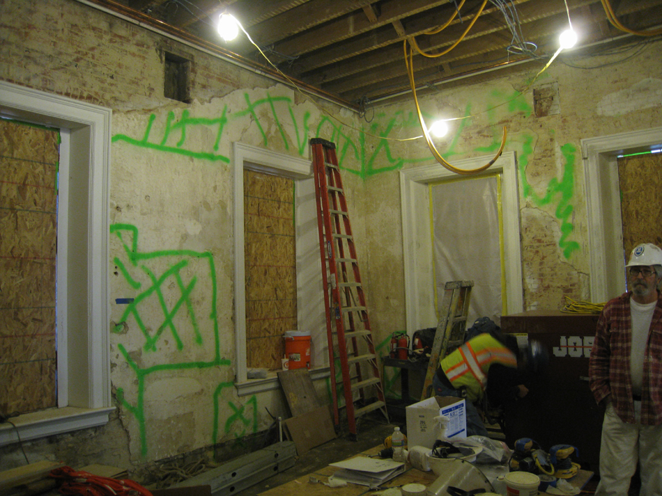 Second Floor--Northeast room--North and east walls.  Selective baring of wall for plaster replacement and restoration.  (Green markings to be removed)