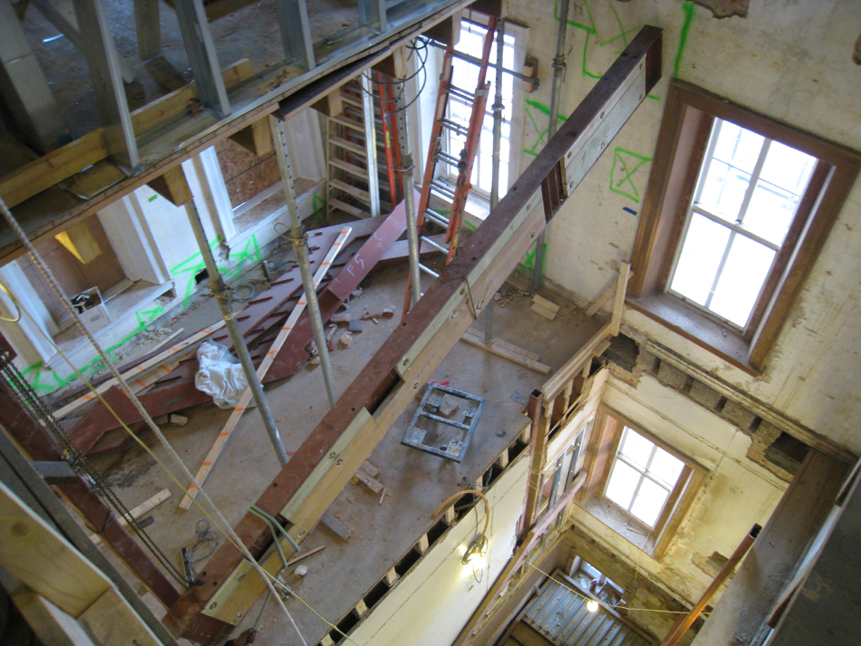 Third Floor--Looking down east stairwell as beam is being raised into place