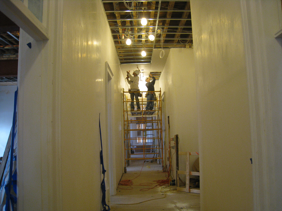 Second Floor--Installing drywall on the ceiling in the central corridor (looking west) - March 14, 2011