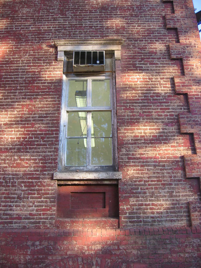 The workers are scraping the paint from the frames of the windows.